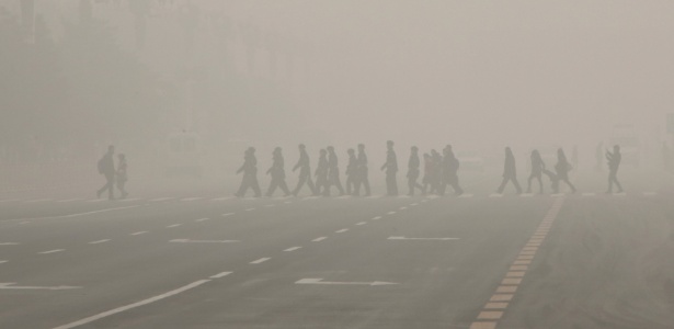 Pedestres e policiais caminham pela praça Tiananmen durante dia poluído em Pequim - Kim Kyung-Hoon/Reuters