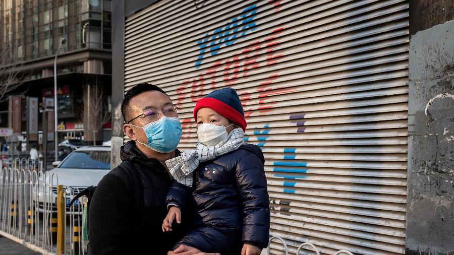7.mar.2020 - Homem e criança usam máscara como medida preventiva contra o coronavírus em Pequim, na China - Nicolas Asfouri/AFP
