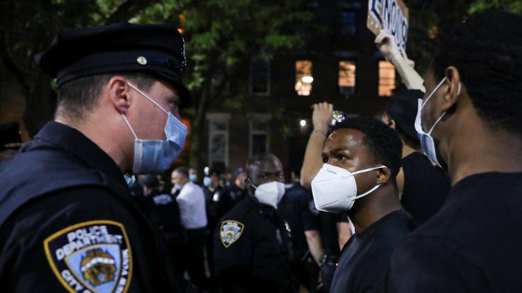 Um manifestante encara um policial durante um protesto após a morte do afro-americano George Floyd