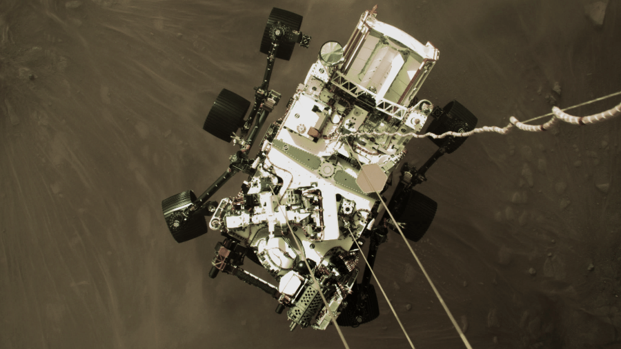 Robô Perseverance quando estava pousando em Marte, visto do foguete que auxiliou em sua descida - Nasa