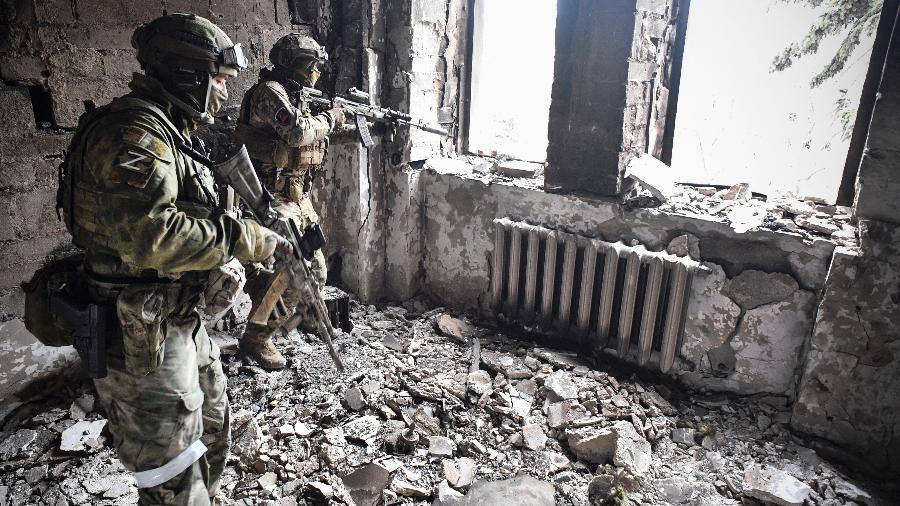 Dois soldados russos patrulham o teatro de Mariupol, bombardeado em 16 de março - Alexander NEMENOV/ AFP