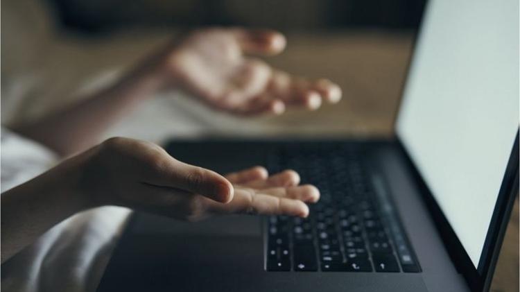 Mãos em frente a tela de computador laptop - Getty Images - Getty Images