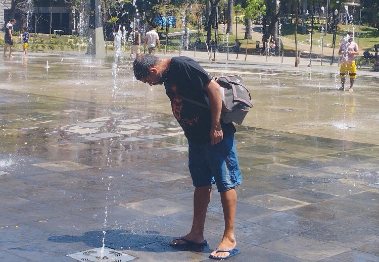 Homem molha a cabeça nas fontes de água do Vale do Anhangabaú