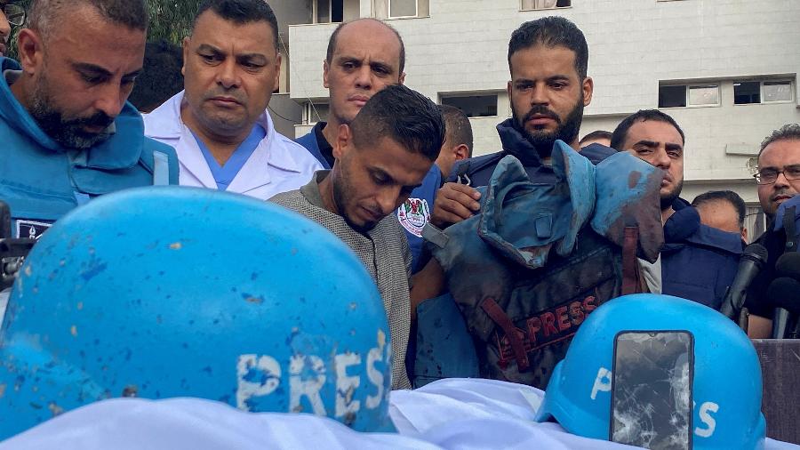 Colegas dos jornalistas palestinos Mohammed Soboh e Saeed al-Taweel, que foram mortos quando um míssil israelense atingiu um prédio enquanto eles estavam do lado de fora de uma reportagem, ao lado de seus corpos em um hospital na Cidade de Gaza, 10 de outubro de 2023