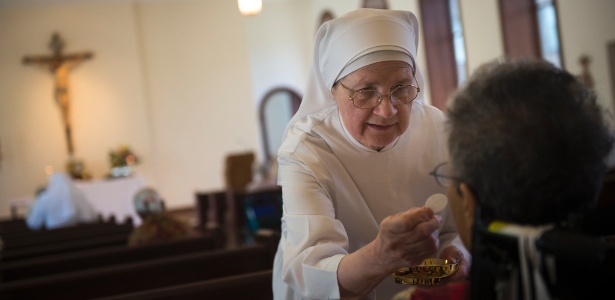Freira oferece hóstia na capela da Little Sisters of the Poor, em Washington - Gabriella Demczuk/The New York Times