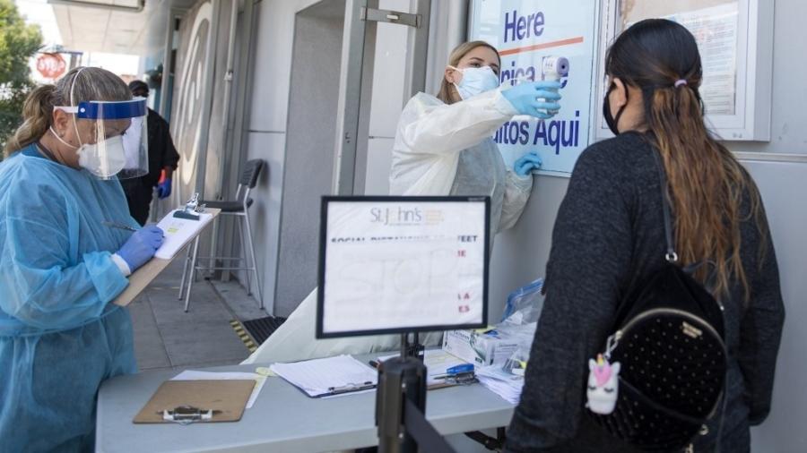 24.07.2020 - Coronavírus: Paciente tem temperatura medida para entrar em centro de saúde em Los Angeles, na Califórnia (EUA) - Por Emma Farge