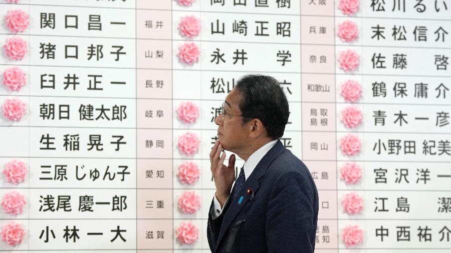 10.jul.2022 - O primeiro-ministro do Japão e o presidente do Partido Liberal Democrático (LDP) Fumio Kishida observa depois de colocar uma rosa de papel vermelha no nome de um candidato do LDP para indicar a vitória na eleição da câmara alta, na sede do partido em Tóquio - TORU HANAI / POOL / AFP