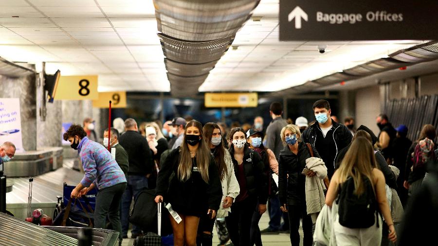 Viajantes usam máscaras para impedir a propagação da covid-19em aeroporto nos EUA - REUTERS/Kevin Mohatt