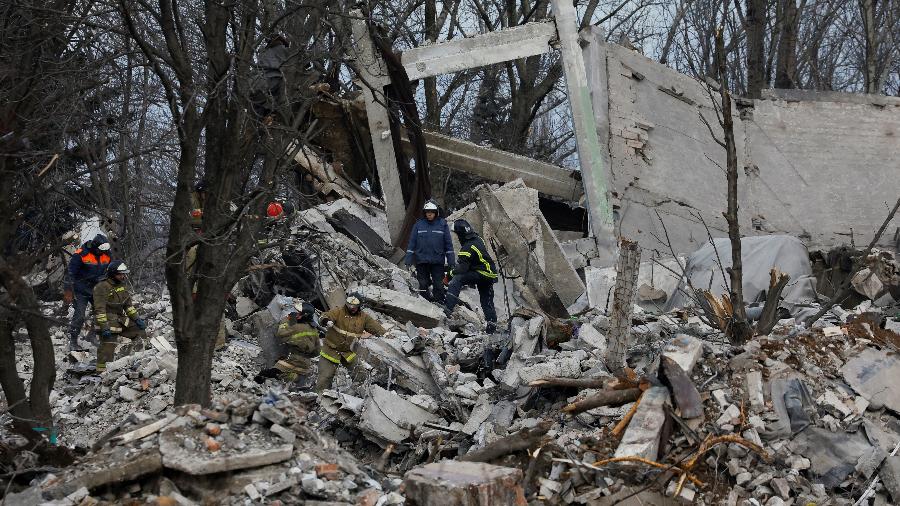 04.jan.23 - Trabalhadores removem destroços de um prédio destruído que supostamente seria uma escola vocacional usada como acomodação temporária para soldados russos - ALEXANDER ERMOCHENKO/REUTERS