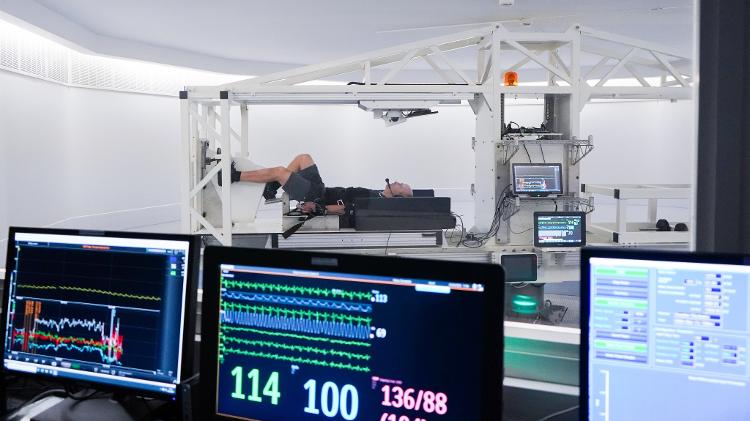 experimento-de-pessoa-deitada-pedalando-enquanto-e-girada-em-uma-centrifuga-1685202038278_v2_750x421 Agência Europeia vai pagar voluntários para ficarem 2 meses em cama