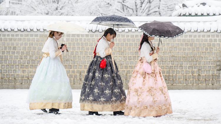 Mulheres em trajes típicos passeiam pelo jardim do Palácio Gyeongbokgung após a maior nevasca já registrada em Seul