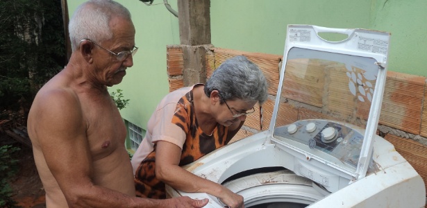 Cenita e Francisco Romualdo observam a máquina de lavar destruída pela lama -  Thiago Alves/MAB (Movimento dos Atingidos por Barragens) 