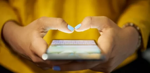 Mulher digita em smartphone; texting; sms; celular - iStock - iStock