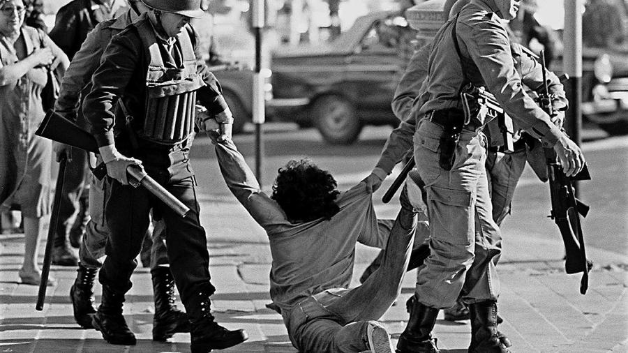 Manifestante é arrastado durante protesto contra a ditadura militar argentina em 30 de março de 1982 - DANIEL GARCIA/AFP