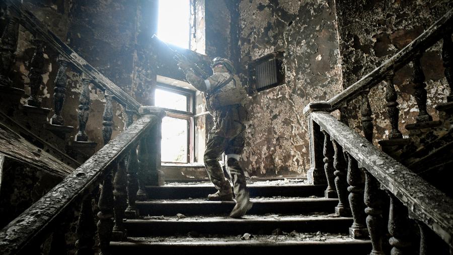 12.abr.2022 - Um soldado russo sobe escadas no teatro de drama de Mariupol, atingido em 16 de março por um ataque aéreo - Alexander Nemenov/AFP