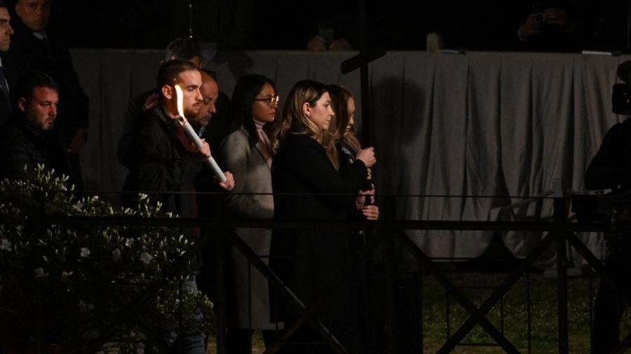 15.4.2022 - A ucraniana Irina (esq) e a russa albina Albina (dir), ambas enfermeiras, carregaram juntas uma cruz durante a Via Crucis em Roma - Tiziana FABI / AFP