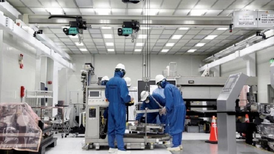 Técnicos da SMIC operam máquina durante produção de chips, na China - Divulgação/ SMIC