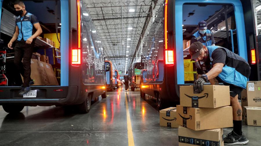 16.nov.22 - Trabalhadores carregam pacotes em caminhões elétricos Amazon Rivian em uma instalação da Amazon em Poway, Califórnia, EUA - SANDY HUFFAKER/REUTERS