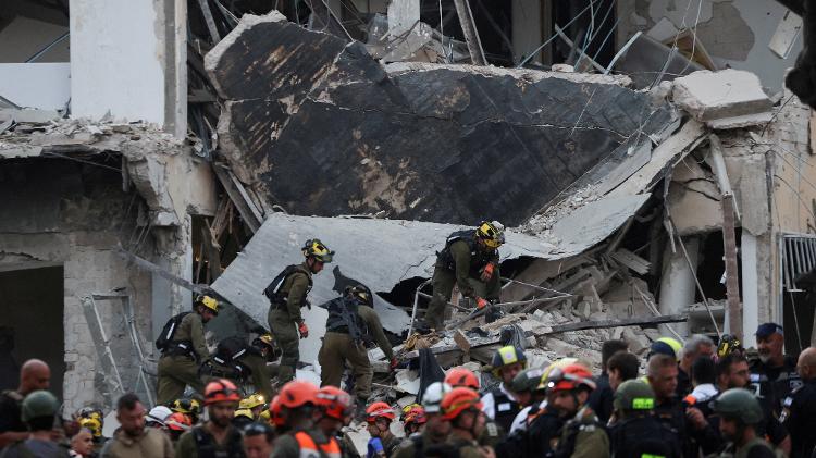 Equipe de resgate trabalha em meio a escombros em edifício atingido por mísseis do Irã em Tel Aviv