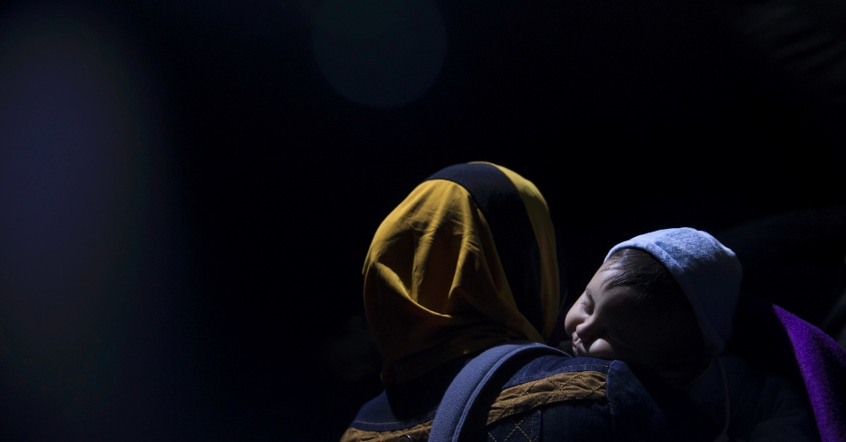 19.out.2015 - Mulher imigrante espera para atravessar a fronteira com a Croácia, perto da Vila de Bekasovo, na Sérvia