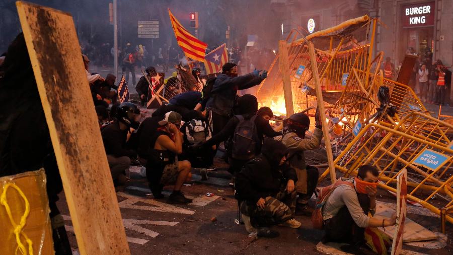 18.out.2019 - Manifestantes usam grades como barricadas durante protesto em Barcelona - Pau Barrena/AFP