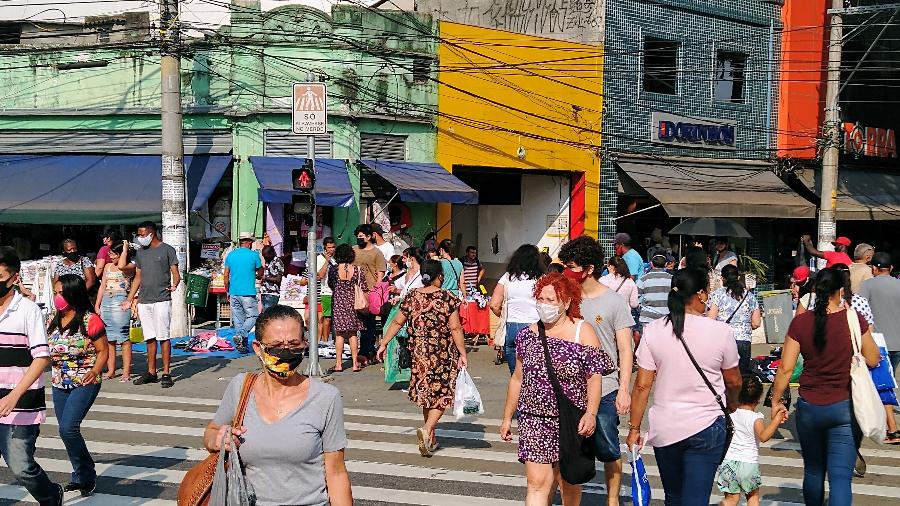 Pessoas usando máscara caminham pelo bairro de Santo Amaro, na zona sul da cidade de São Paulo durante a pandemia do novo cornavírus - Cleber Souza/UOL
