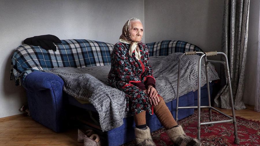 8.mar.2022 - Rozalia Choba, 98, que passou dez anos na Sibéria como prisioneira política, senta-se em um sofá em sua casa na vila de Solonka, nos arredores de Lviv, oeste da Ucrânia - Ionut Iordachescu/AFP