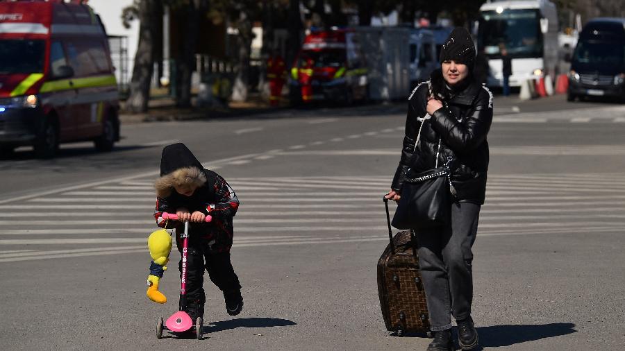 Uma criança e sua mãe chegam a Siret, na Romênia, após cruzarem a fronteira da Ucrânia - CLODAGH KILCOYNE/REUTERS