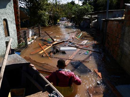 Homem em meio às enchentes no Rio Grande do Sul em junho; tragédia não foi suficiente para derrubar a extrema direita - Diego Vara/Reuters