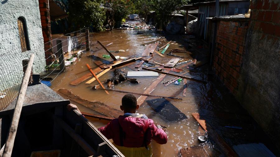 Homem enfrenta enchente no Rio Grande do Sul; inundações extremas são consequência das mudanças climáticas
