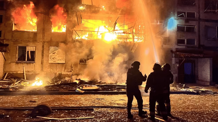 Bombeiros trabalham no local de uma área residencial atingida por um ataque militar russo, na cidade de Dobropillia, região de Donetsk
