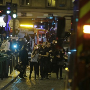 13.nov.2015 - Policiais franceses removem pessoas de rua em Paris, na França, após uma série de ataques na capital francesa. Tiroteios e explosões aconteceram na noite desta sexta-feira (13) na capital francesa. A polícia relatou ao menos duas explosões nas proximidades do estádio Stade de France, onde o presidente francês, François Hollande, acompanhava um amistoso da seleção francesa - Kenzo Tribouillard/AFP