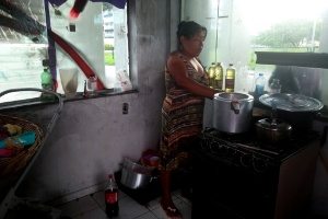 Jandira Santos, 43 anos, cozinha um pouco de arroz para a sua família. Ela e outros 320 indígenas foram acomodados pelo poder público em um terminal de ônibus inutilizado de Florianópolis - Aline Torres/UOL - Aline Torres/UOL