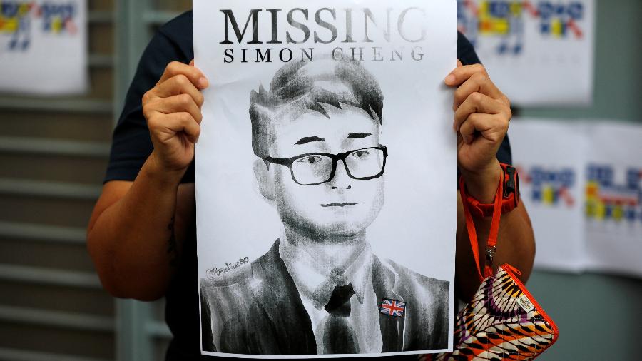 Uma mulher segura o cartaz de desaparecido do funcionário do consulado britânico Simon Cheng - Willy Kurniawan/Reuters