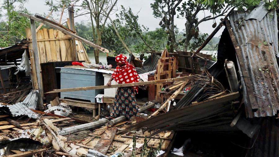 Moradora de Bangladesh recolhe seus pertences após ter casa destruída por ciclone Amphan - STRINGER