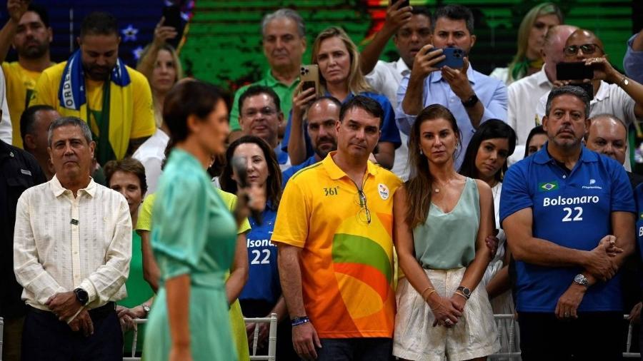 À direita, Arthur Lira com a camisa que faz propaganda de Bolsonaro. A partir da esquerda, general Braga Netto, Michelle Bolsonaro (de verde, em primeiro plano) e Flávio Bolsonaro, acompanhado de sua mulher - Mauro Pimentel/AFP