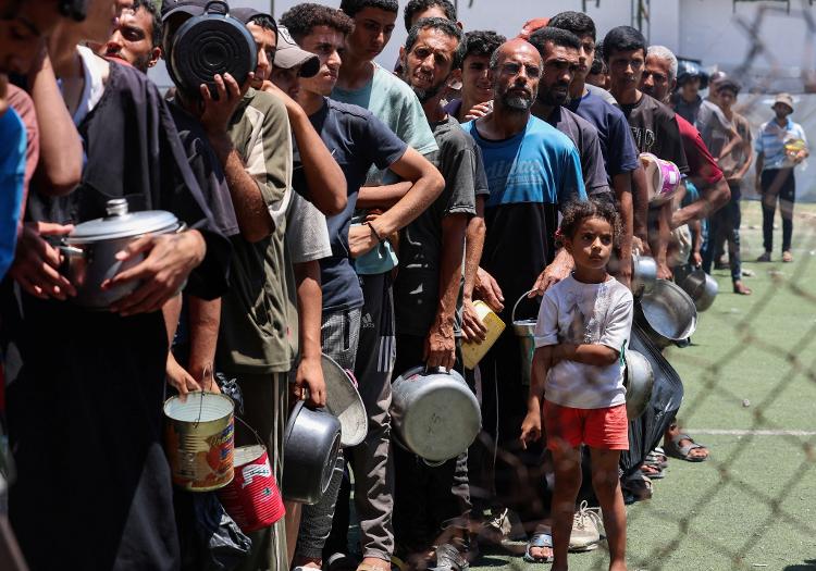 Palestinos em fila para receber comida em Nuseirat Palestinos em fila para receber comida em Nuseirat
