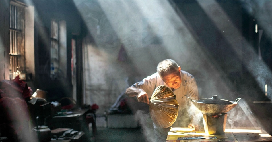14.set.2015 - Uma idosa de 79 anos de idade cozinha em sua casa na província de Anhui, na China