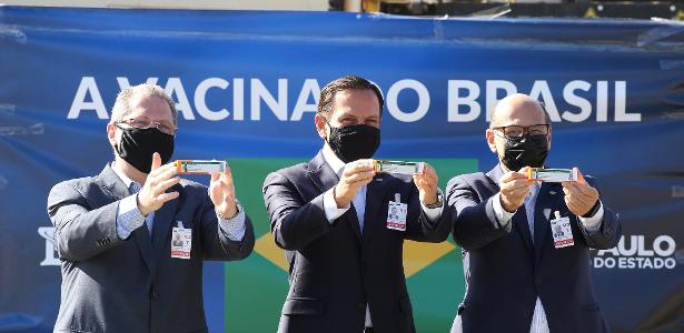 O governador de São Paulo, João Doria (PSDB), o secretário estadual de Saúde, Jean Gorinchteyn, e o diretor do Instituto Butantan, Dimas Covas, recebem doses da CoronaVac no Aeroporto Internacional de Guarulhos, em São Paulo