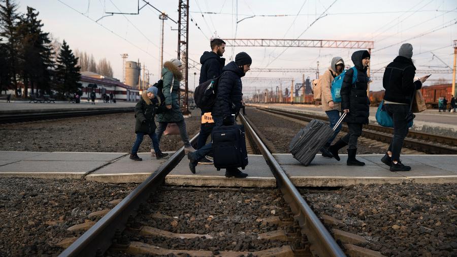 24.fev.2022 - Moradores cruzam linha de trem durante evacuação da cidade de Kramatorsk, no leste da Ucrânia - Tyler Hicks/The New York Times