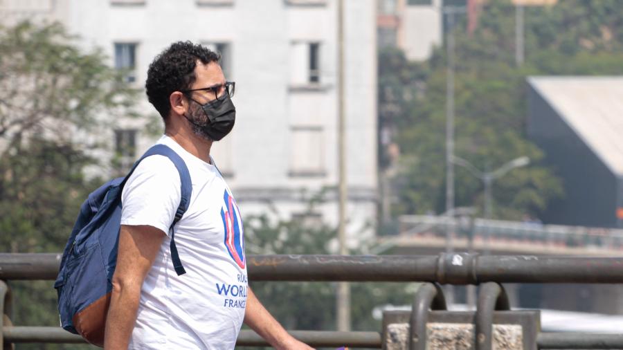 Vista de pedestre usando máscara, para se proteger da poluição e baixa umidade do ar