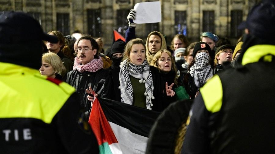 13.nov.2024 - Uma manifestante segura uma bandeira da Palestina em frente a policiais durante ato pró-Palestina