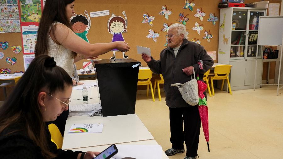Um eleitor entrega a cédula de voto a funcionários da sessão eleitoral em Espinho, Portugal, 18 de maio de 2025 - Violeta Santos Moura/REUTERS