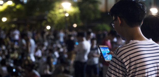Jovem joga Pokémon Go em parque de Hong Kong - Ng Wing Kin/ Xinhua