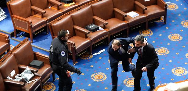 06 jan. 2021 - Policiais retiram políticos de plenário do Congresso após invasão de manifestantes favoráveis ao presidente Donald Trump