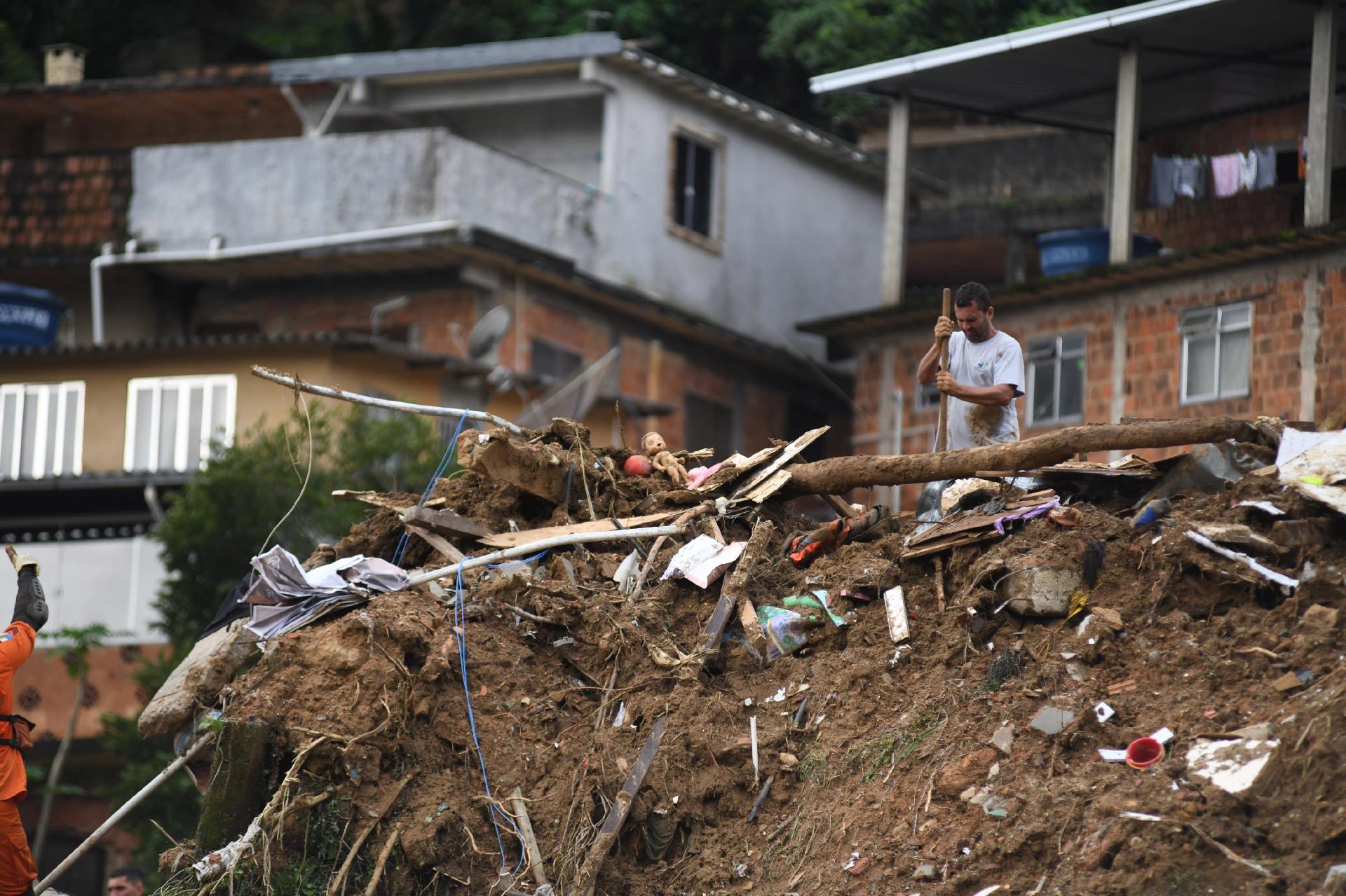 Bombeiros e moradores trabalham na busca de desaparecidos e de pertences em encosta que deslizou sobre casas em Petrópolis - Lucas Landau/UOL