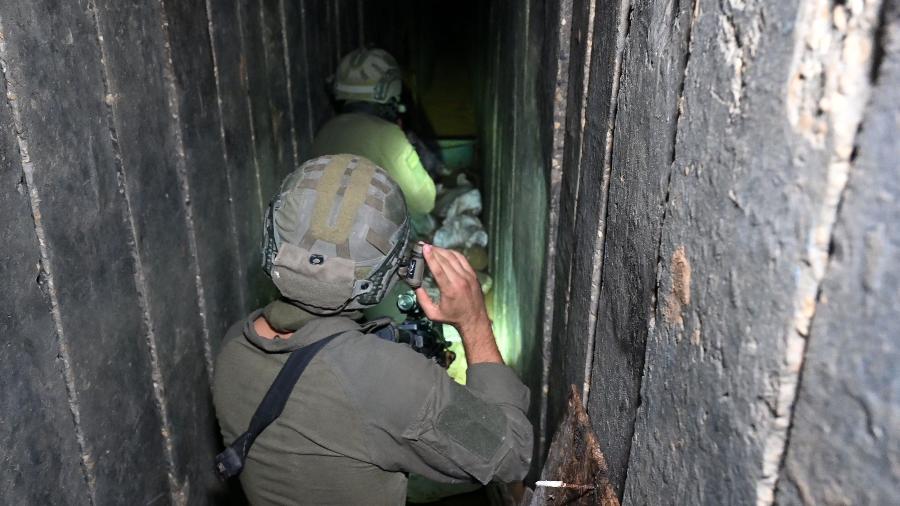Soldados atravessam o que o exército israelense diz ser um túnel cavado pelo Hamas dentro do complexo hospitalar Al-Shifa em Gaza