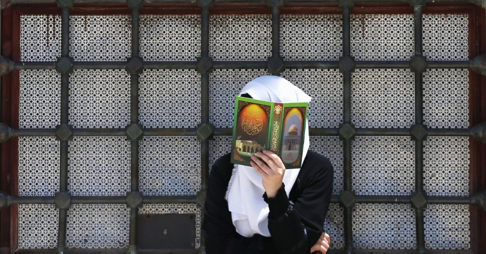 3.jul.2015 - Mulher palestina lê um Corão na terceira sexta-feira do mês sagrado do Ramadã no complexo conhecido pelos muçulmanos como o Nobre Santuário e para os Judeus como Monte do Templo, em Jerusalém, na Faixa de Gaza
