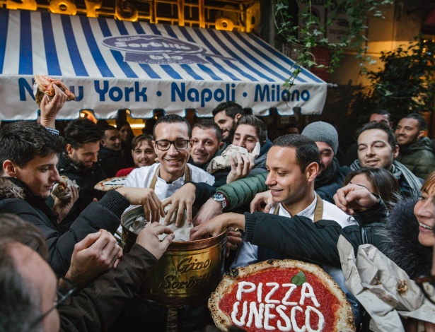 O pizzaiolo Gino Sorbillo distribui pizza gratuita para celebrar o reconhecimento da UNESCO da arte napolitana de se fazer pizza  - GIOVANNI CIPRIANO/NYT