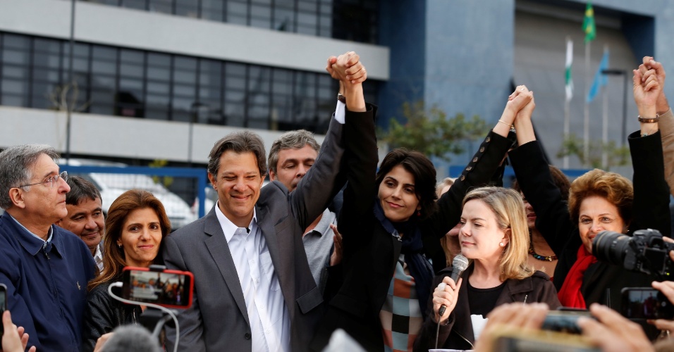11.set.2018 - Fernando Haddad levanta mão de Manuela D'àvila após encontro com ex-presidente Lula para oficialização da chapa